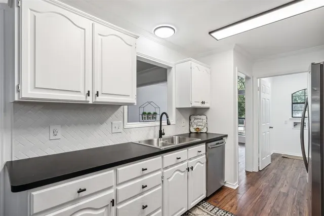 a kitchen with granite countertop white cabinets and a sink