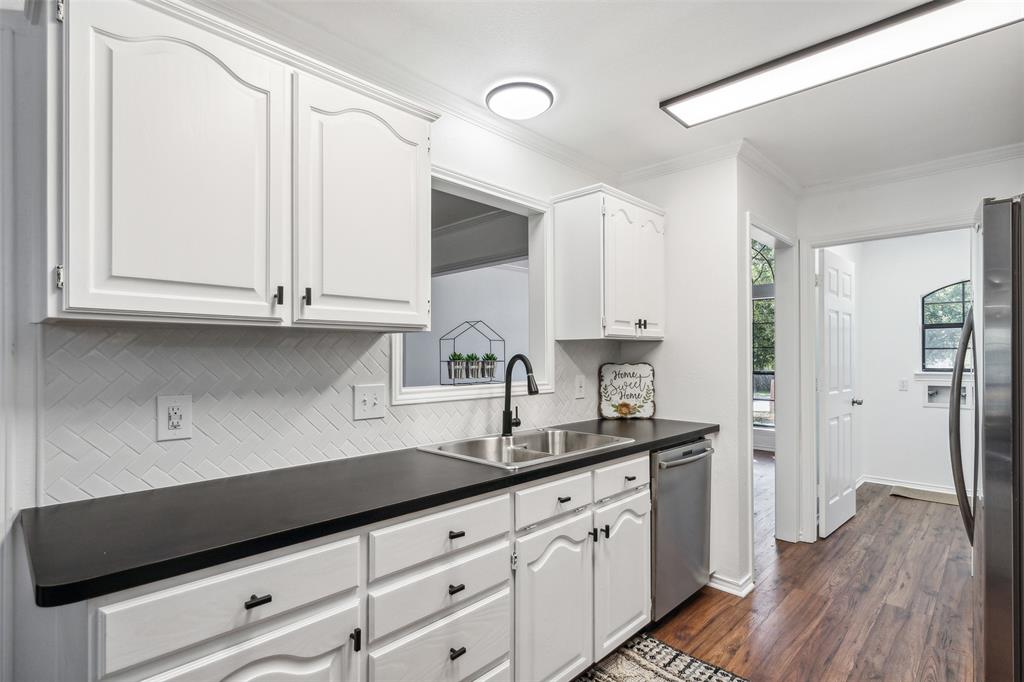 215 Shady Oak Road Keene, TX 76059 - Photo 9 of 26 a kitchen with granite countertop white cabinets and a sink