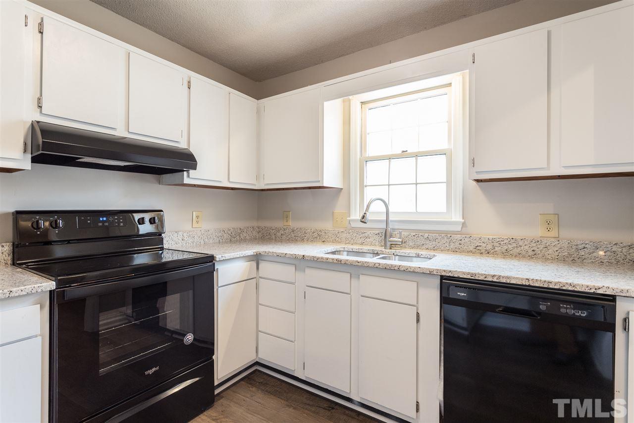 5630 Bridgetowne Way Raleigh, NC 27609 - Photo 8 of 26 a kitchen with granite countertop a stove sink and cabinets