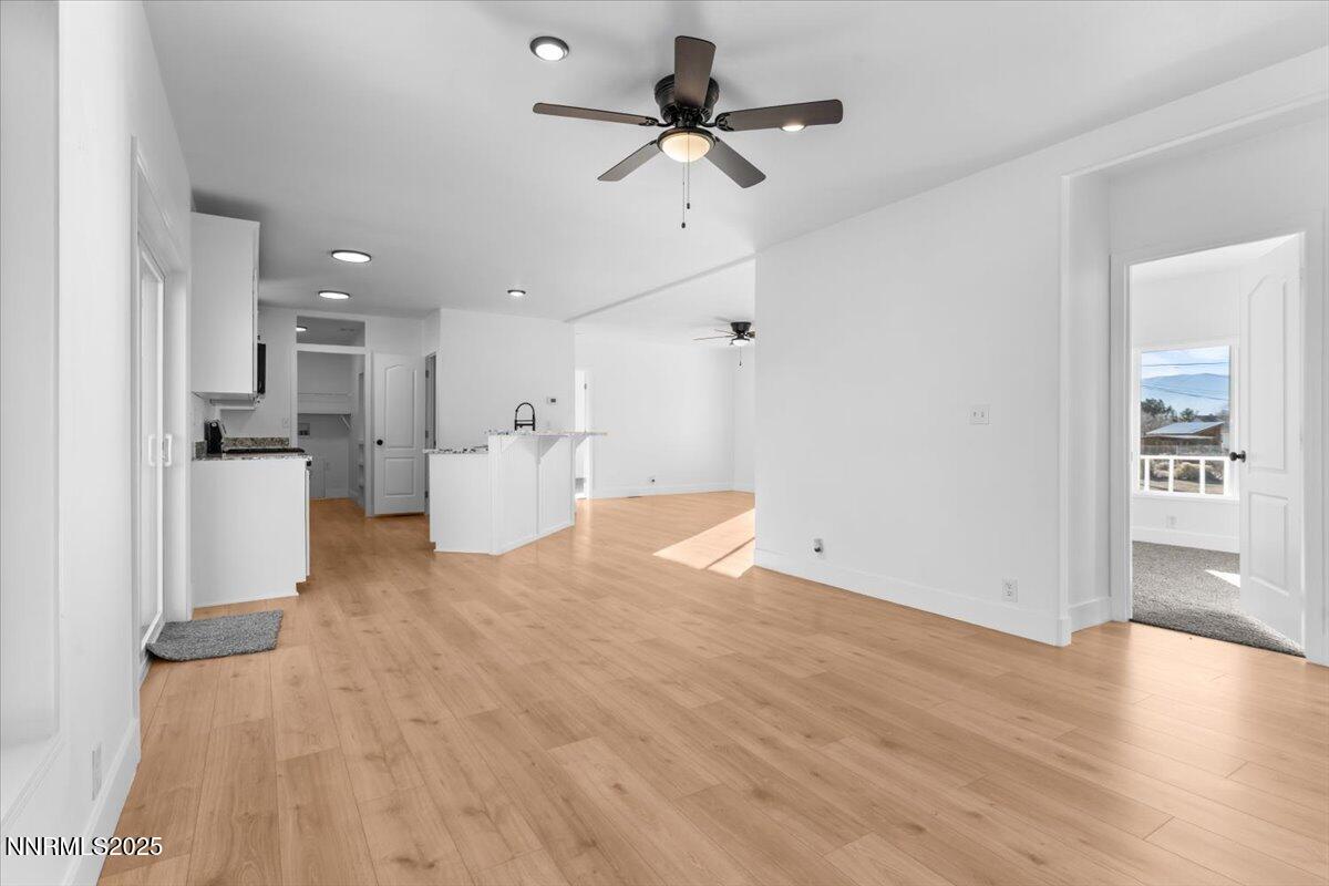 11305 Fir Drive Reno, NV 89506 - Photo 13 of 35 a view of empty room with wooden floor and kitchen view