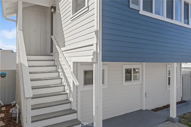 an empty room with wooden floor cabinet and windows