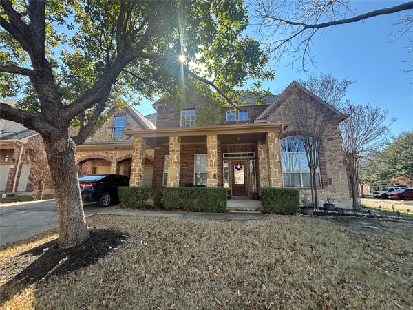 a front view of a house with a yard and potted plants