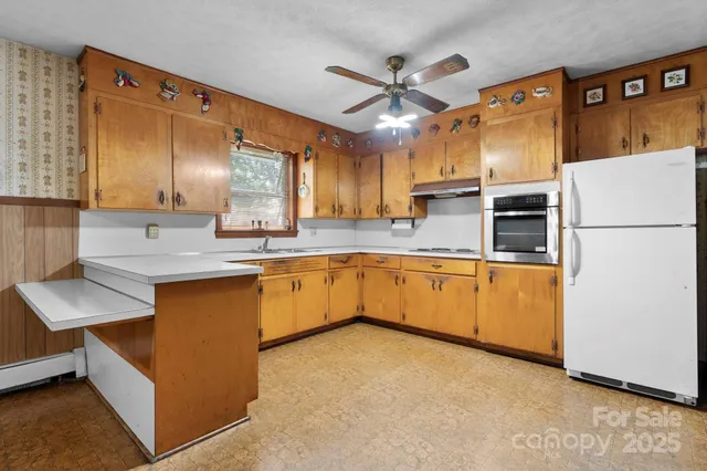 a kitchen with cabinets a sink and white appliances