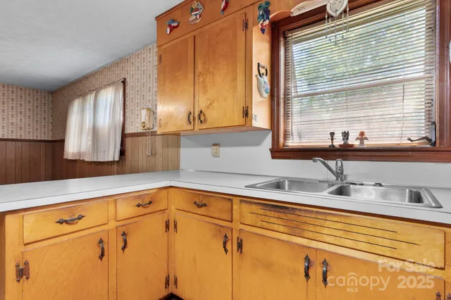 a kitchen with stainless steel appliances white cabinets and a window