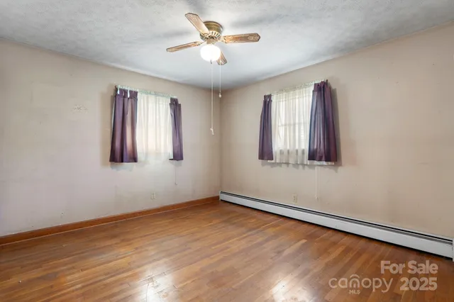 a view of a room with wooden floor and a window
