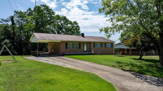 a front view of a house with a yard and trees