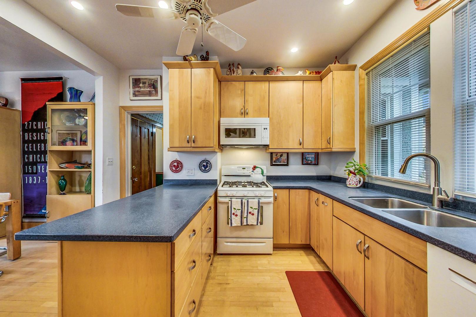 7221 North Ridge Boulevard Chicago, IL 60645 - Photo 12 of 48 a kitchen with stainless steel appliances granite countertop a sink stove and refrigerator
