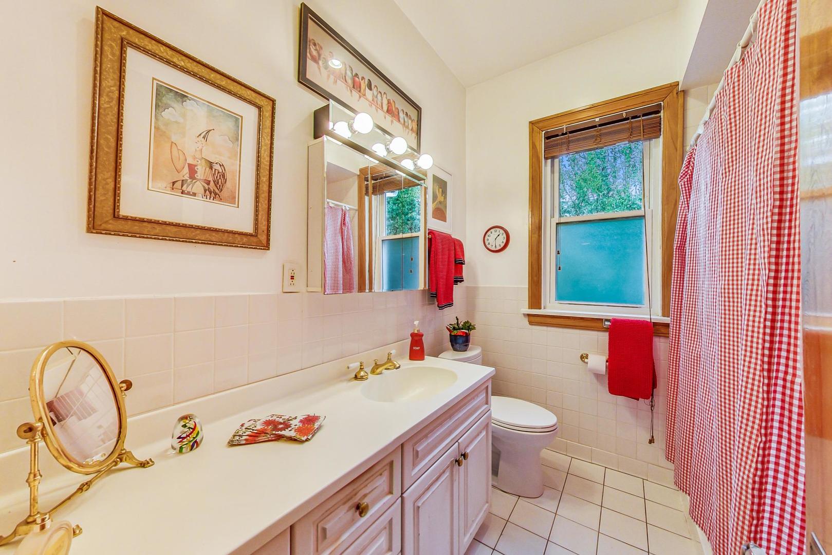 7221 North Ridge Boulevard Chicago, IL 60645 - Photo 20 of 48 a bathroom with a granite countertop sink mirror vanity and toilet