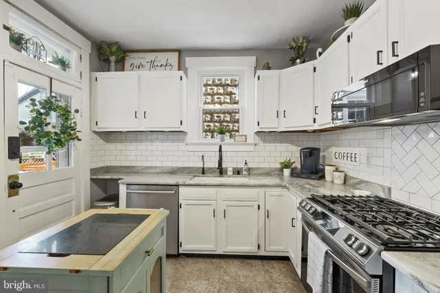 a kitchen with granite countertop a sink stove and cabinets