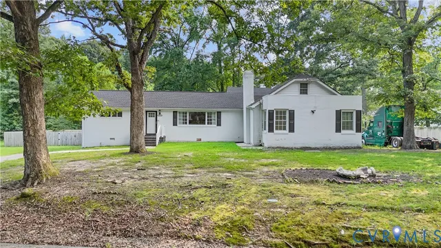 a sign that is sitting in front of a house with big yard
