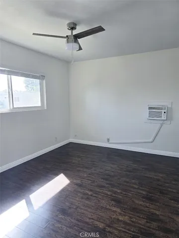 a view of a room with wooden floor and fan