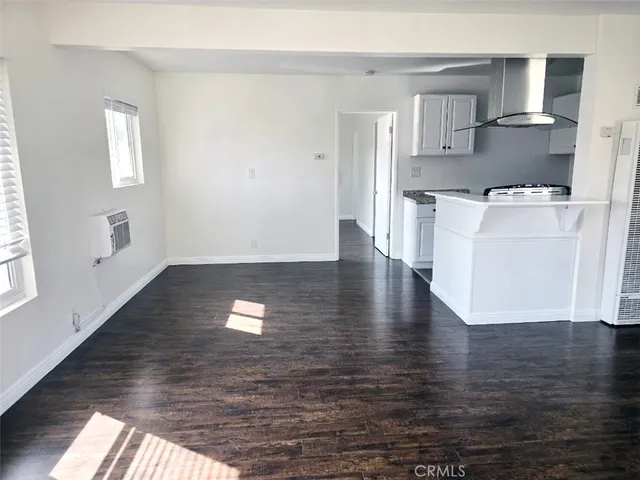a view of a kitchen with wooden floor and electronic appliances