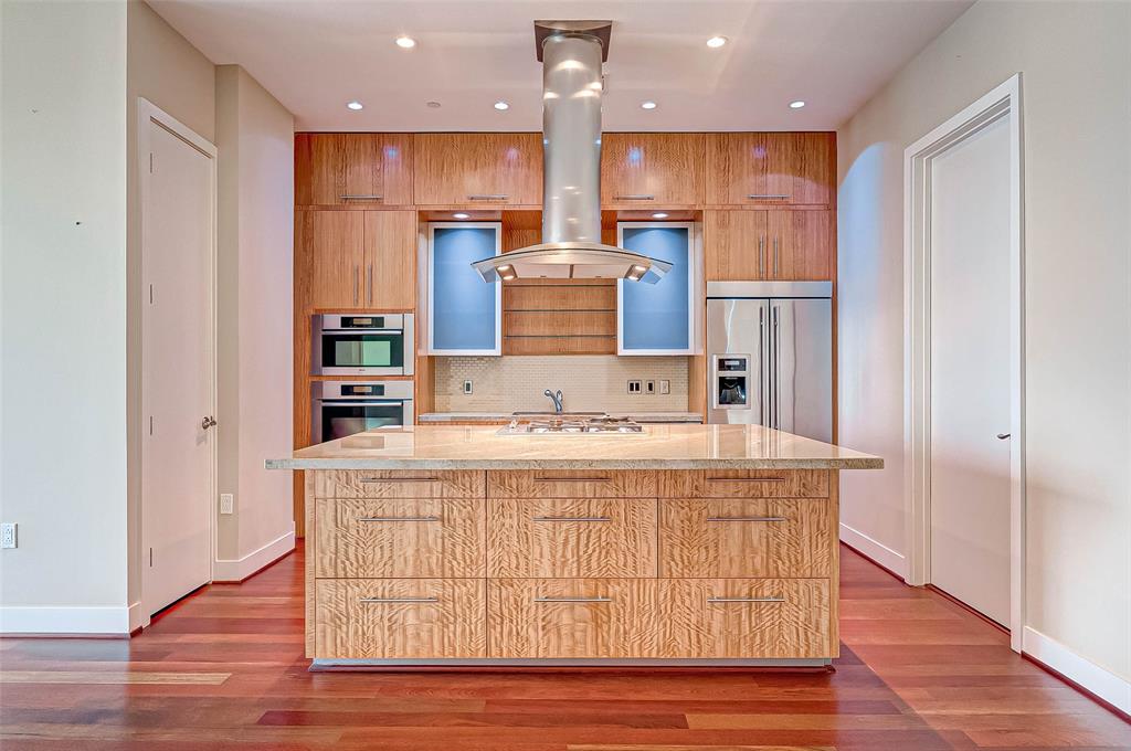 a kitchen with kitchen island stainless steel appliances a sink and refrigerator