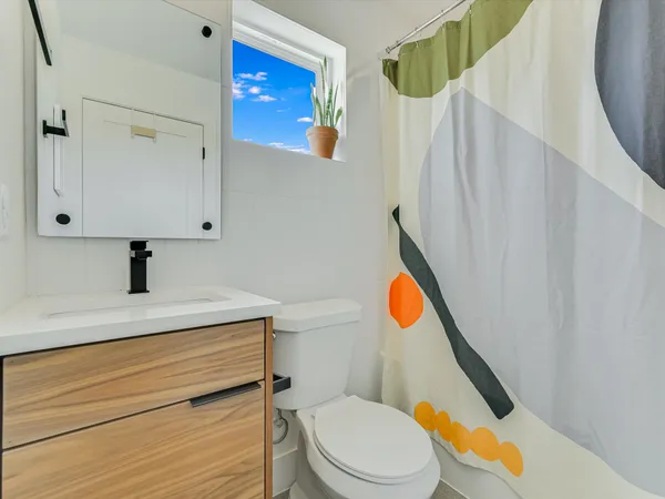 a bathroom with a sink a toilet and shower