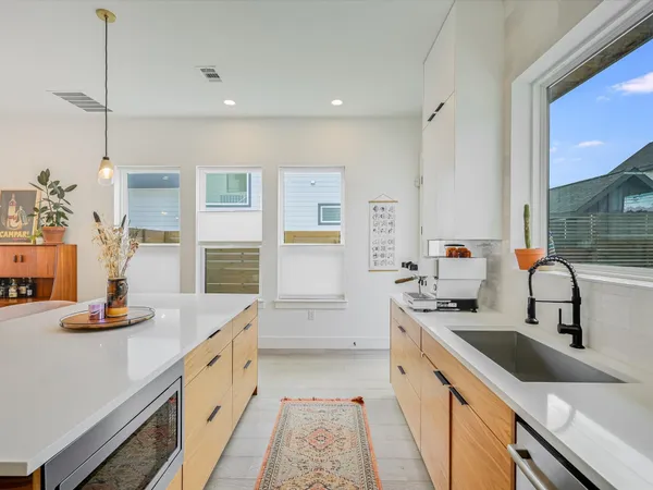 a kitchen with white cabinets and sink