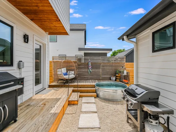 a view of a patio with table and chairs with wooden floor and fence
