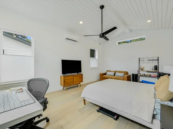 a bedroom with furniture and a flat screen tv