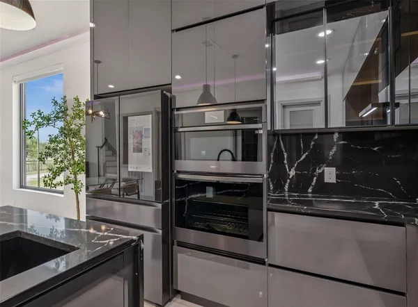 a kitchen with granite countertop a sink and stainless steel appliances