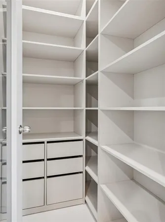 a view of walk in closet with empty racks