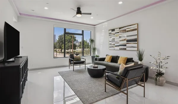 a living room with furniture a large window and a flat screen tv