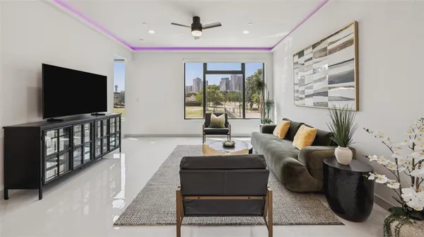 a living room with furniture a flat screen tv and a large window