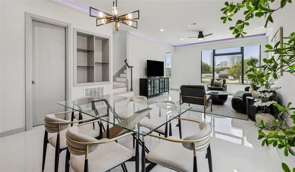 a living room with furniture a chandelier and a flat screen tv