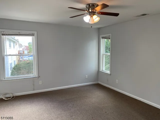 an empty room with a window and a fan