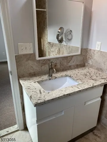 a bathroom with a granite countertop sink and a mirror