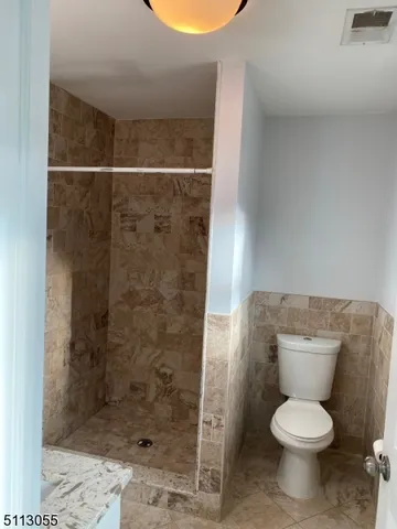 a white toilet sitting next to a shower