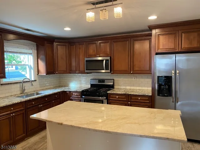 a kitchen with a sink a stove top oven and refrigerator