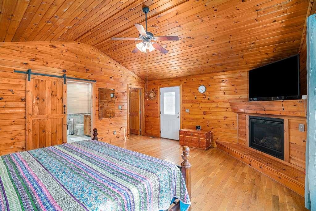 370 Davis Road Blue Ridge, GA 30513 - Photo 15 of 47 a spacious bedroom with a bed and a flat screen tv