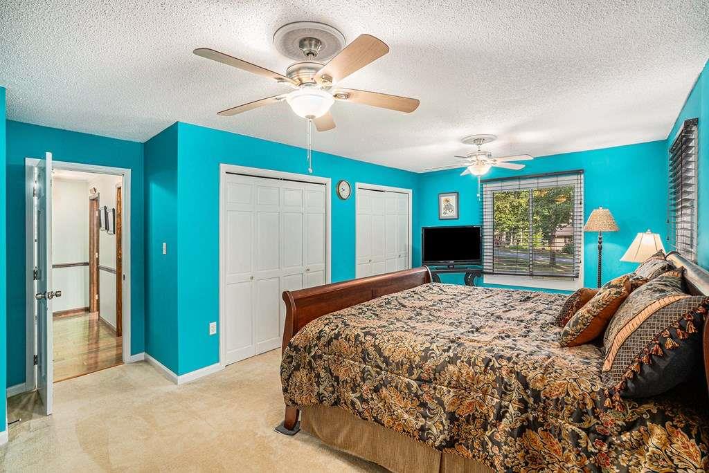 370 Davis Road Blue Ridge, GA 30513 - Photo 21 of 47 a bedroom with a bed and a chandelier