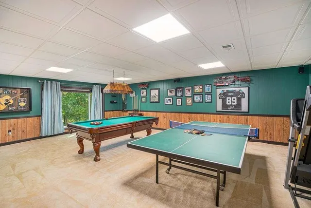 a room with furniture pool table and window