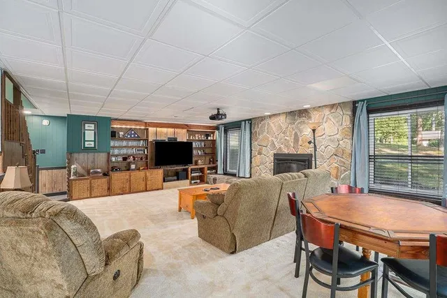 a living room with furniture a flat screen tv and a large window