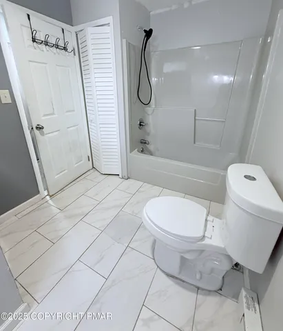 a bathroom with a toilet and a shower