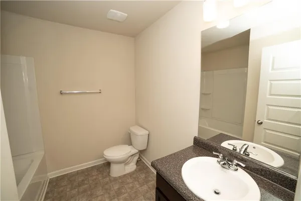 a bathroom with a toilet a sink and mirror