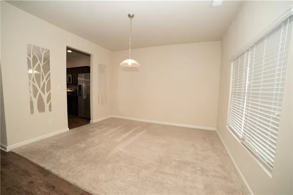 a view of an empty room with window and cabinet