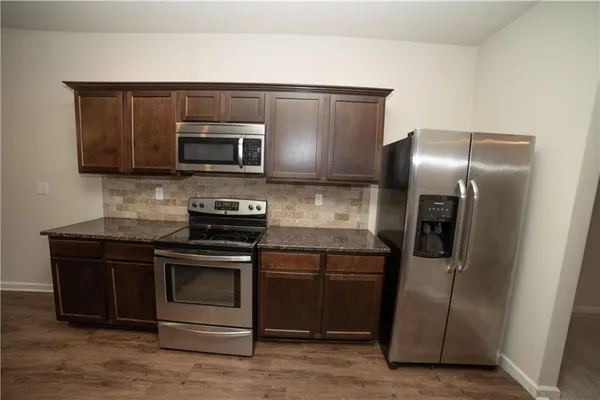 a kitchen with granite countertop a refrigerator and a stove