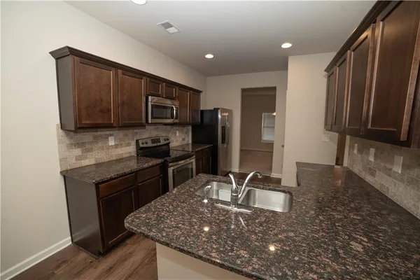 a kitchen with granite countertop stainless steel appliances and wooden cabinets
