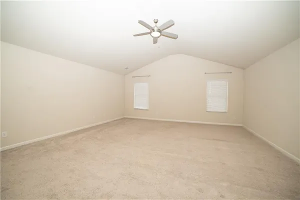 an empty room with fan and windows