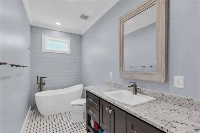 a bathroom with a granite countertop sink a toilet and a bathtub