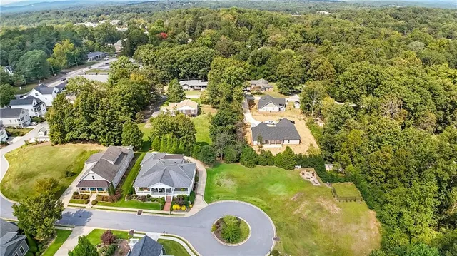 an aerial view of residential house with outdoor space and trees all around