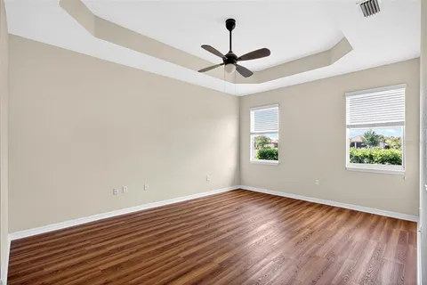 a view of room with window ceiling fan and wooden floor