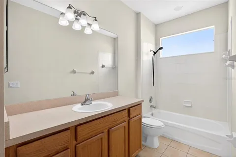 a bathroom with a granite countertop sink a toilet and a bathtub