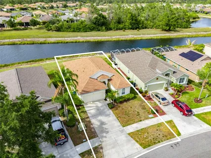 an aerial view of residential houses with outdoor space and river