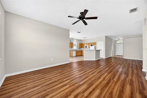 a view of empty room with wooden floor and window