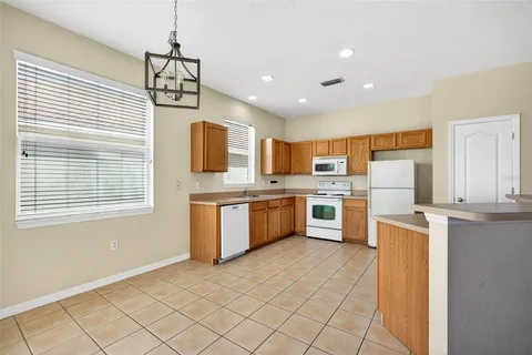 a kitchen with stainless steel appliances a sink a stove a refrigerator cabinets and a window