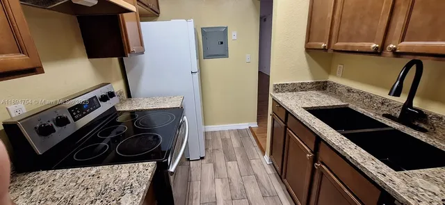 a kitchen with a stove a sink and a refrigerator
