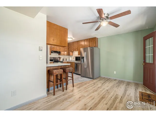 a kitchen with stainless steel appliances kitchen island granite countertop a refrigerator a stove top oven a sink with dishwasher and wooden cabinets