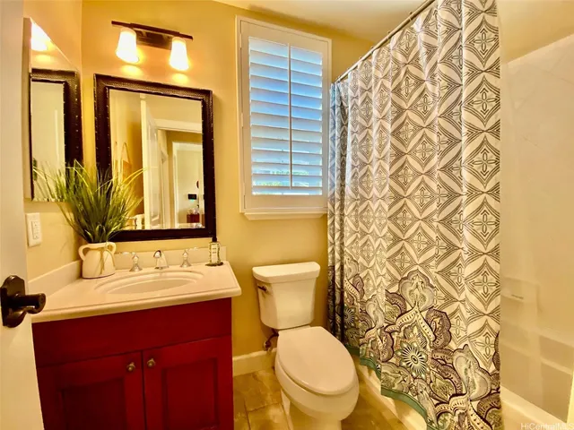 a bathroom with a sink a toilet and shower curtain